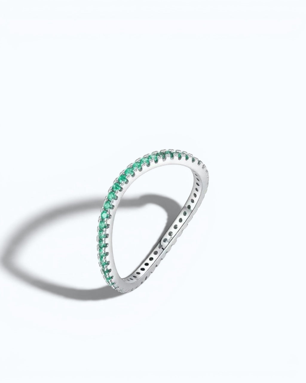 Pearlystones delicate eternity band ring featuring vibrant emerald-green stones set in a polished silver band.