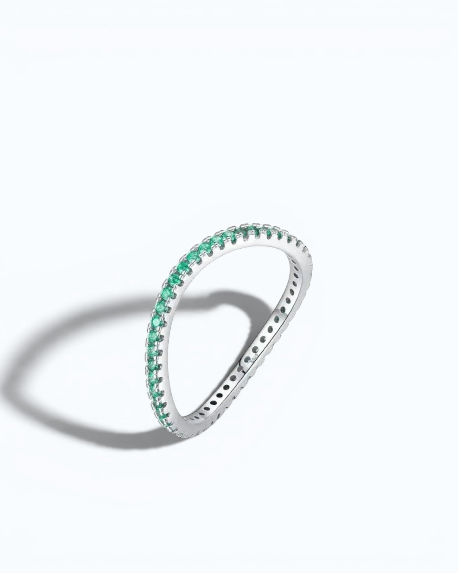 Pearlystones delicate eternity band ring featuring vibrant emerald-green stones set in a polished silver band.