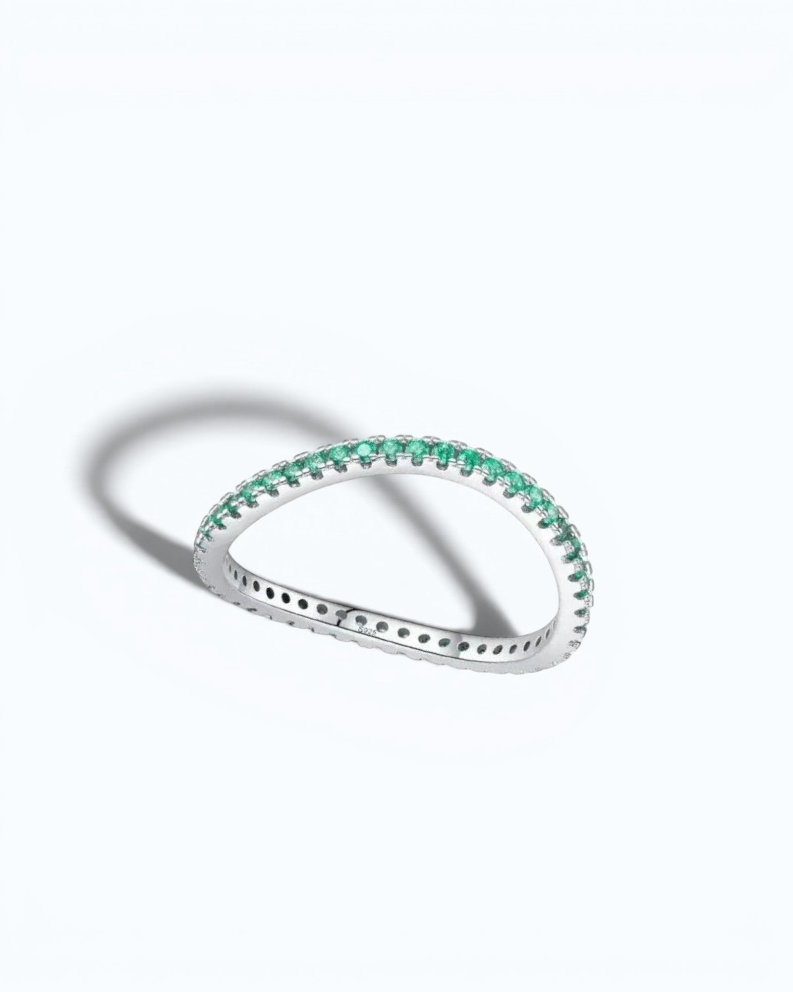 Pearlystones delicate eternity band ring featuring vibrant emerald-green stones set in a polished silver band.