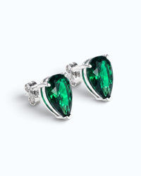 Pearlystones green cubic zirconia water droplet stud earrings in a minimalist silver setting on a white background.