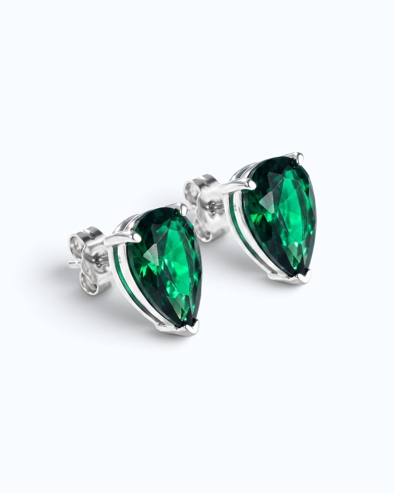 Pearlystones green cubic zirconia water droplet stud earrings in a minimalist silver setting on a white background.
