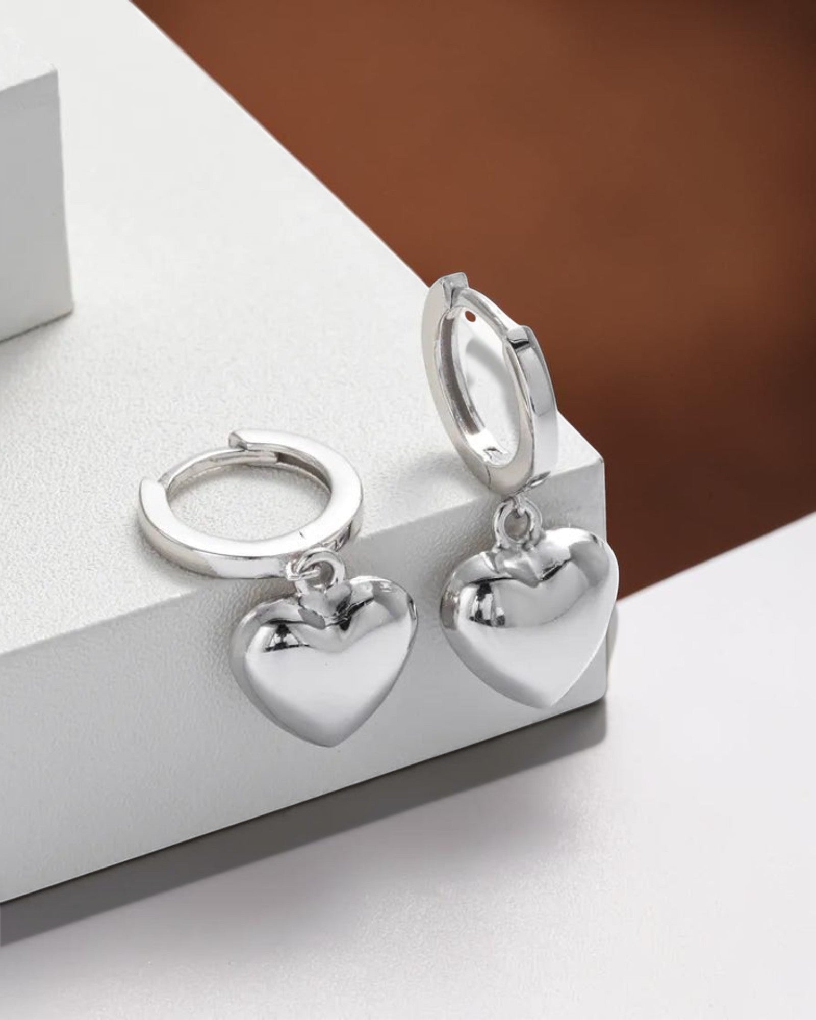 Pearlystones silver heart charm hoop earrings. Classic hoops with puffed heart charms.