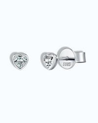 Pearlystones 5mm heart-shaped moissanite stud earrings in rhodium-plated sterling silver with a clean bezel setting.