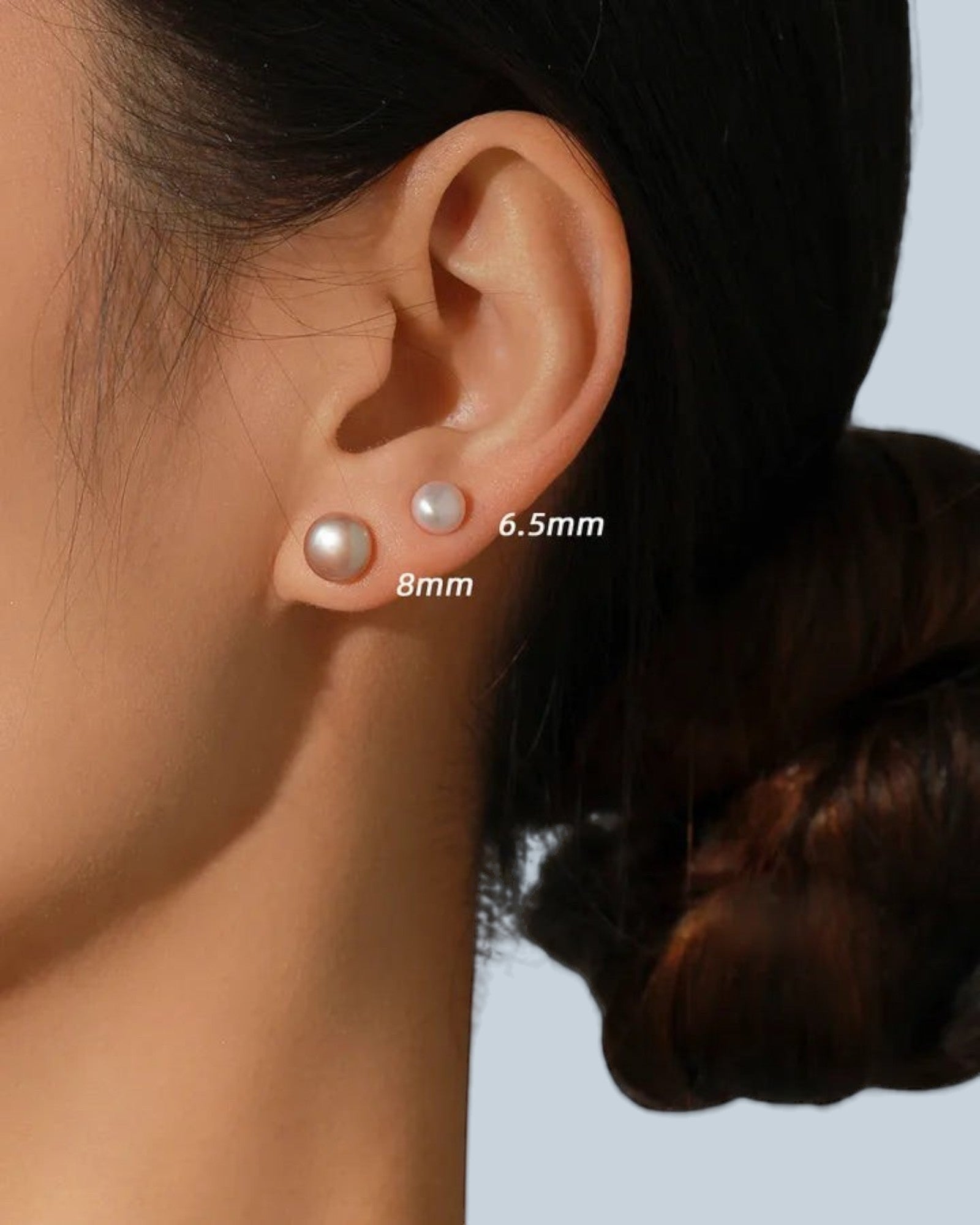 Pearlystones round purple pearl stud earrings in 6.5mm and 8mm sizes worn on a model ear