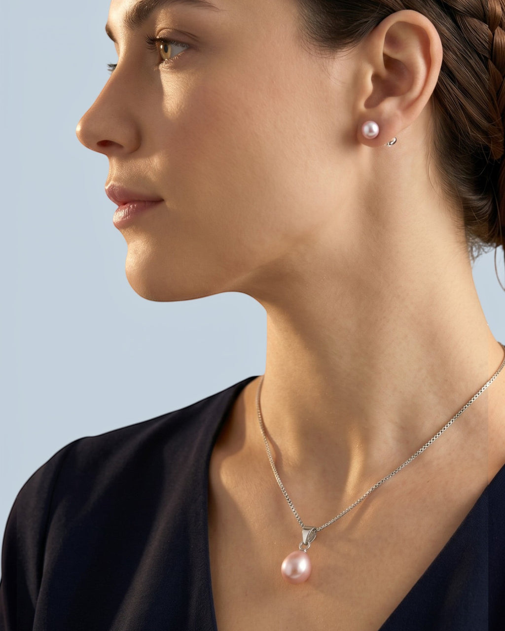 Pearlystones purple teardrop pearl pendant necklace on a silver chain worn by a woman with matching pearl earrings