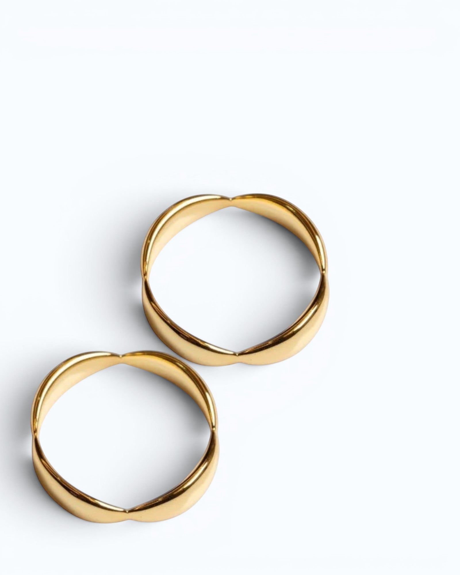 Pearlystones Sculptural Wave Band Ring in polished gold metal with a lustrous finish. Two rings shown.