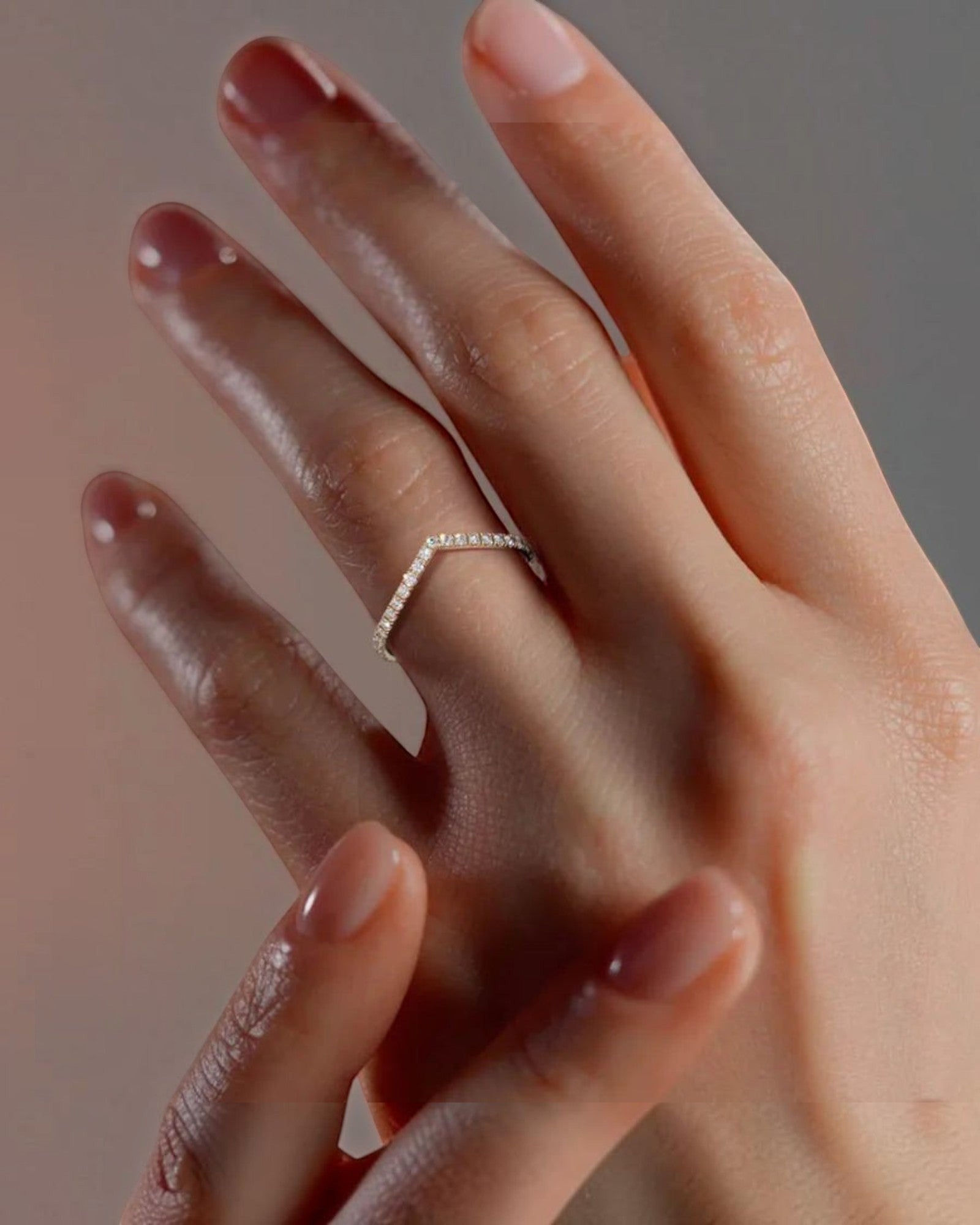 Pearlystones silver chevron ring with pavé-set zircon stones worn on a finger, showcasing a delicate V-shaped band.
