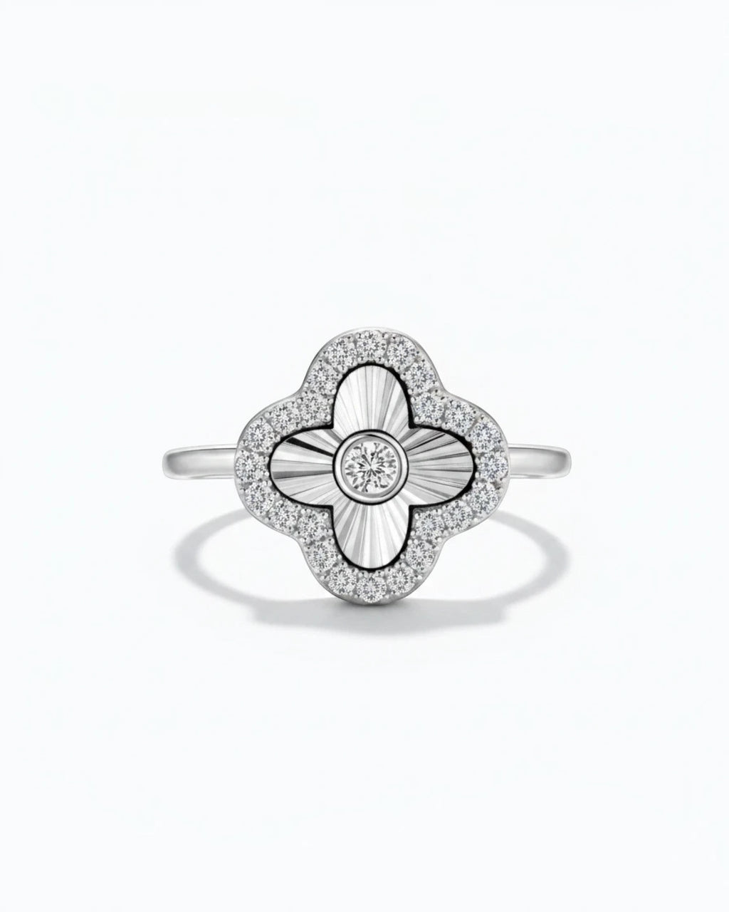 Pearlystones sterling silver clover ring with laser-engraved sunburst petals, bezel-set zircon, and pavé halo.