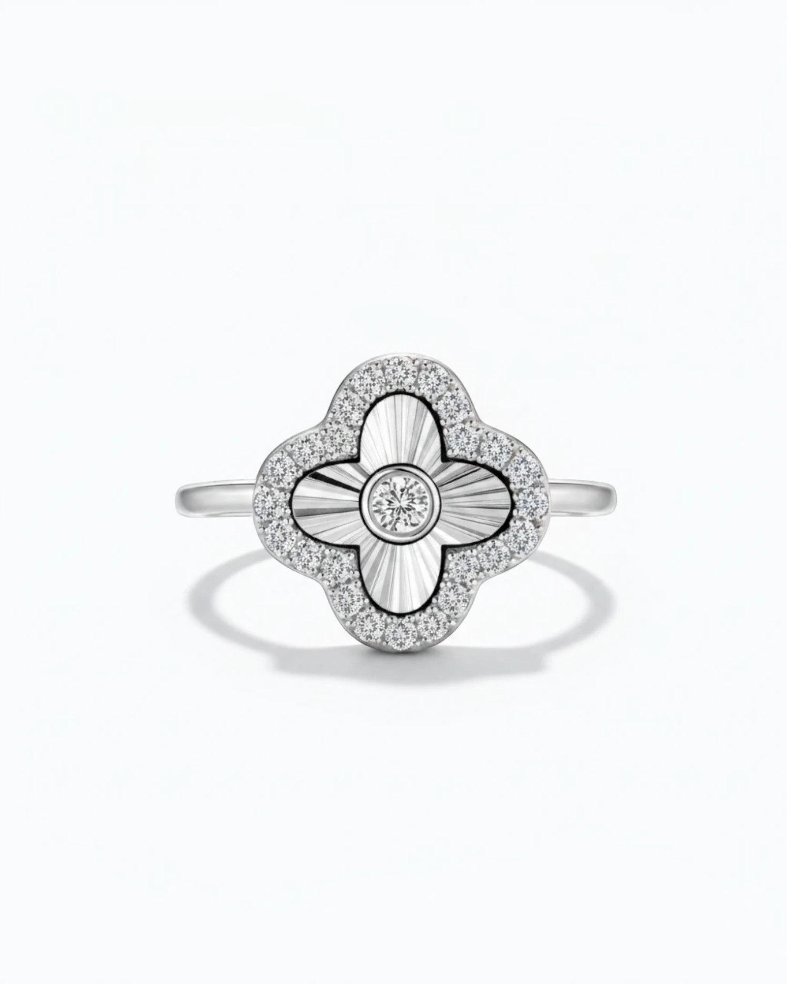 Pearlystones sterling silver clover ring with laser-engraved sunburst petals, bezel-set zircon, and pavé halo.