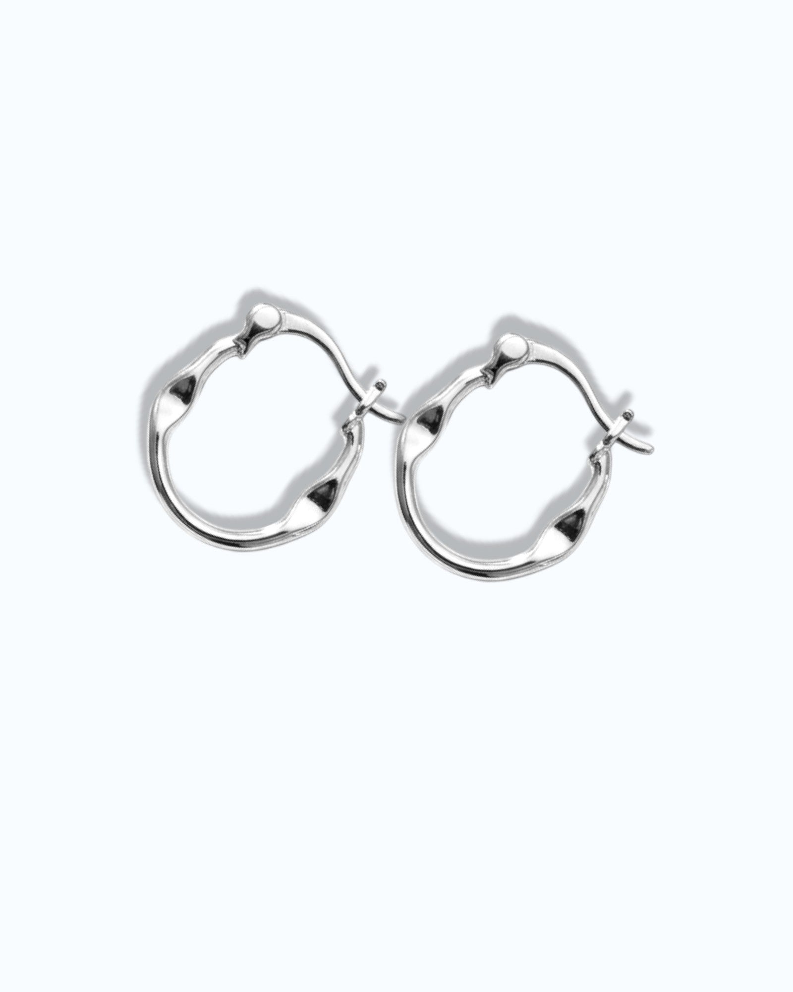 Pearlstones silver medium hoop earrings with a molten, undulating texture and hinged creole closure.