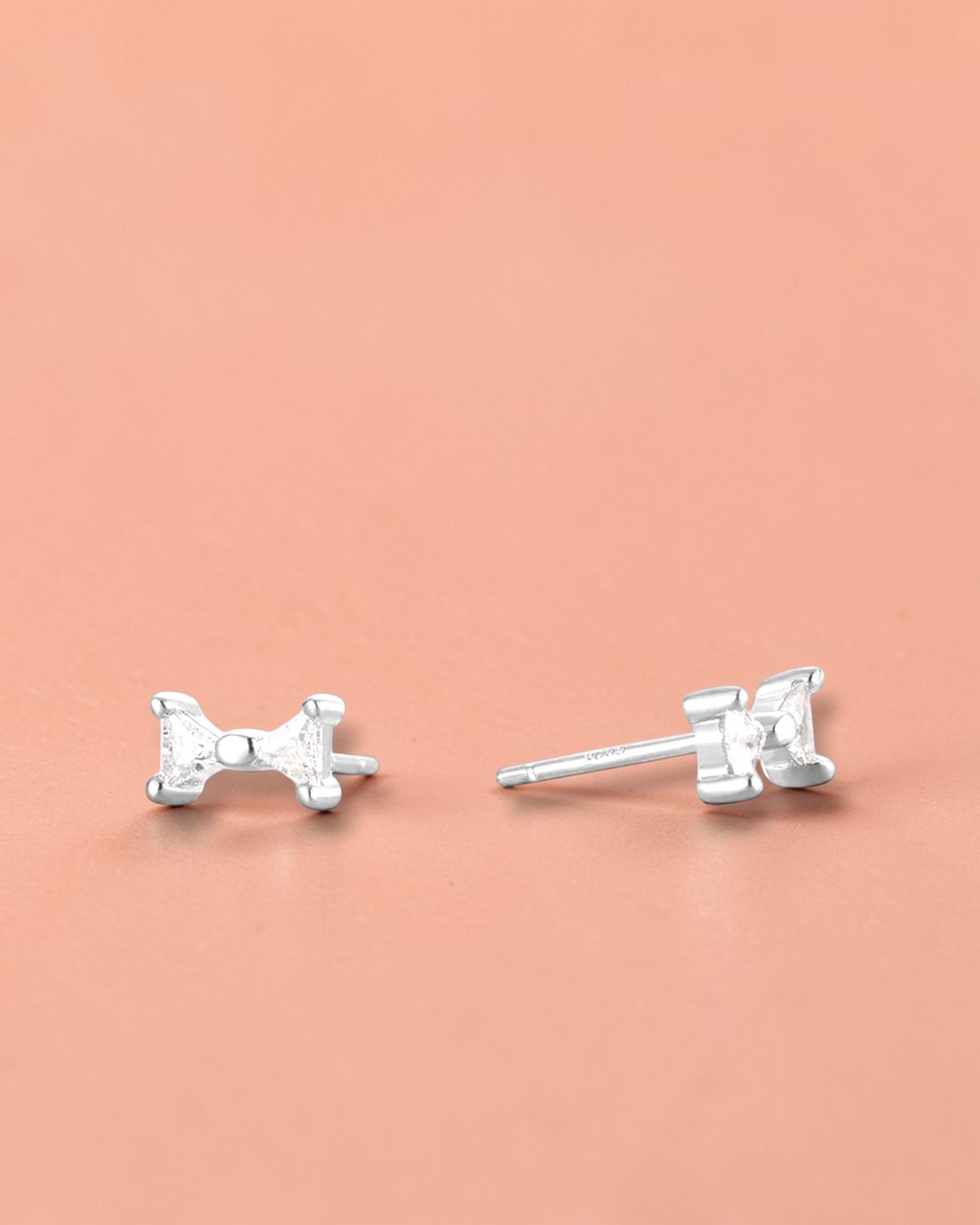 Pearlystones small sterling silver bow stud earrings with white gold plating and cubic zirconia.