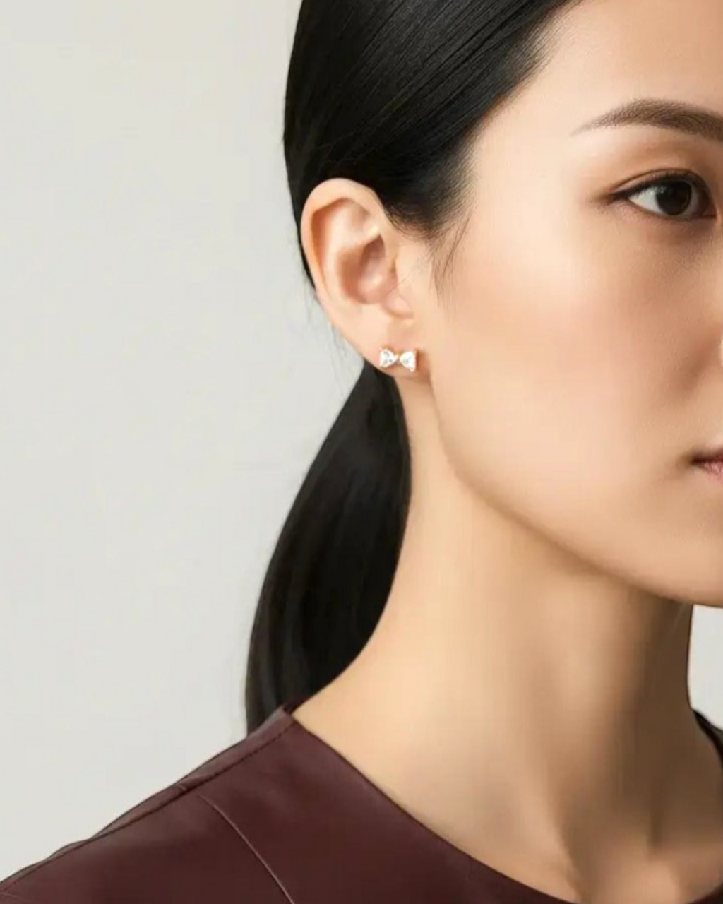 Pearlystones small gold bow stud earrings with cubic zirconia and ball screw back.