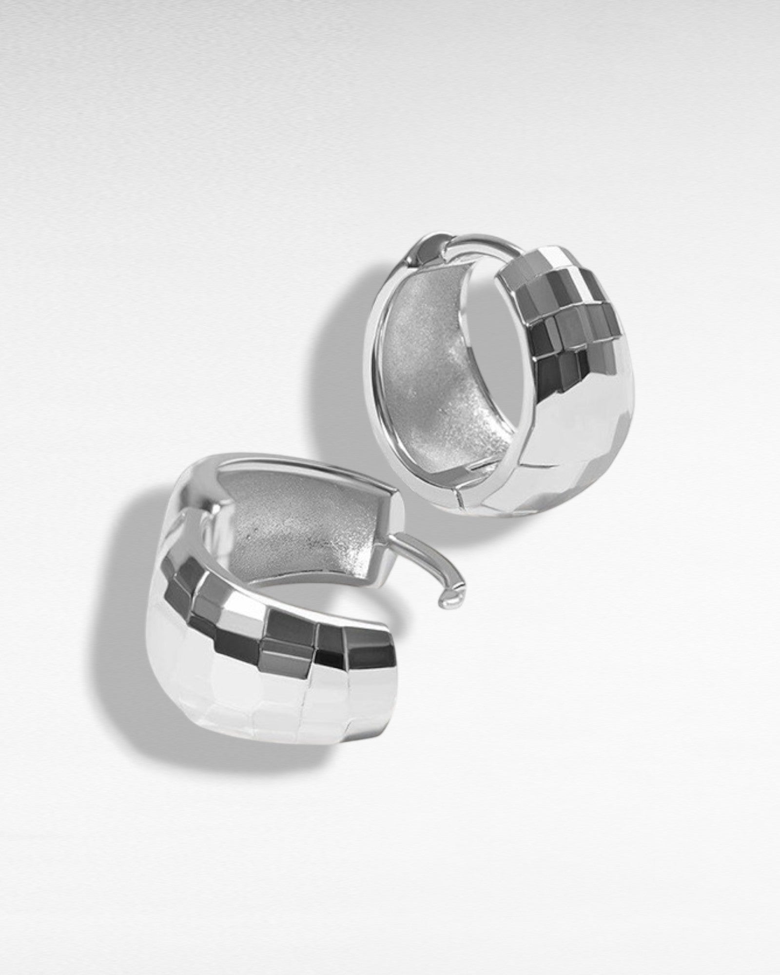 Pearlystones silver-tone sterling silver huggie hoop earrings with geometric texture. Modern, sophisticated hoops for everyday wear.