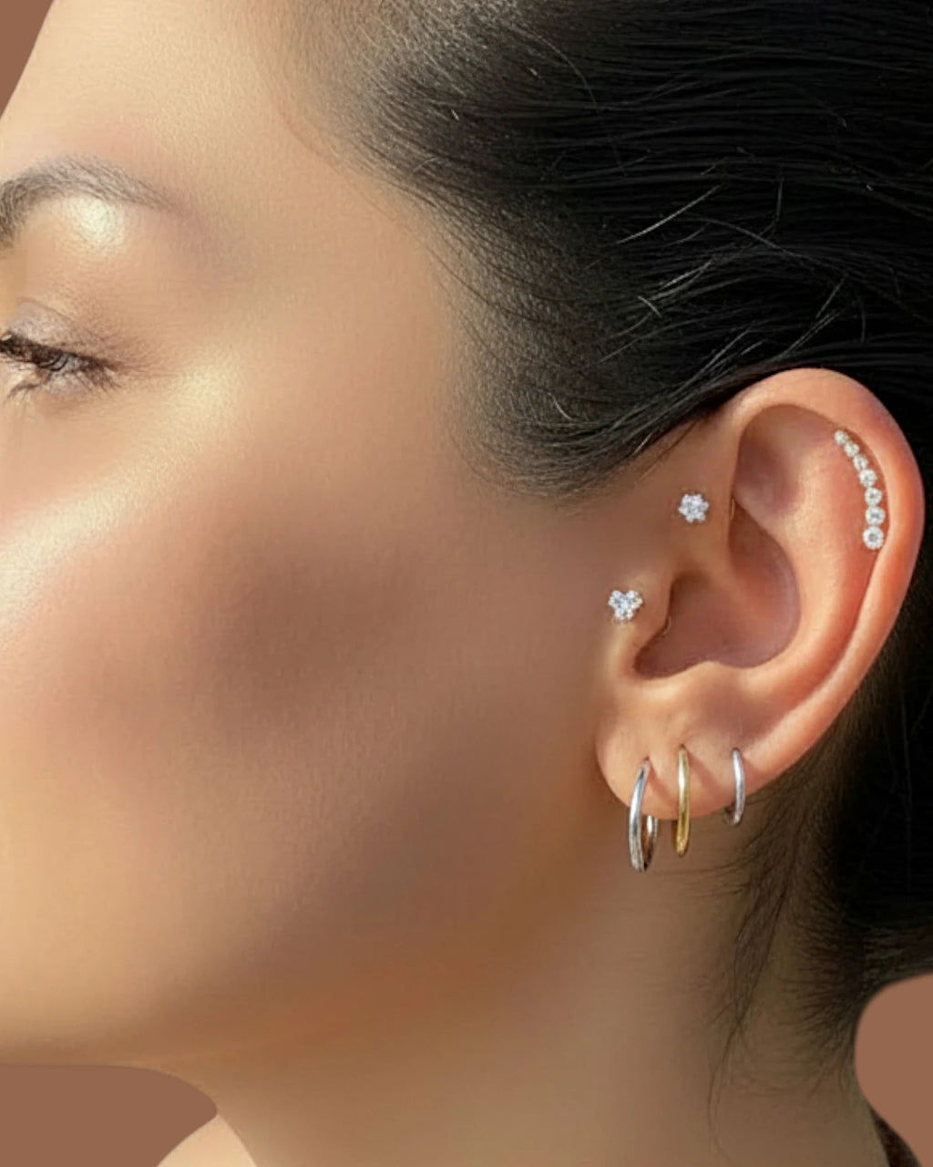 Pearlystones three stone flat back stud earring with cubic zirconia in a triangle shape worn in a cartilage piercing.
