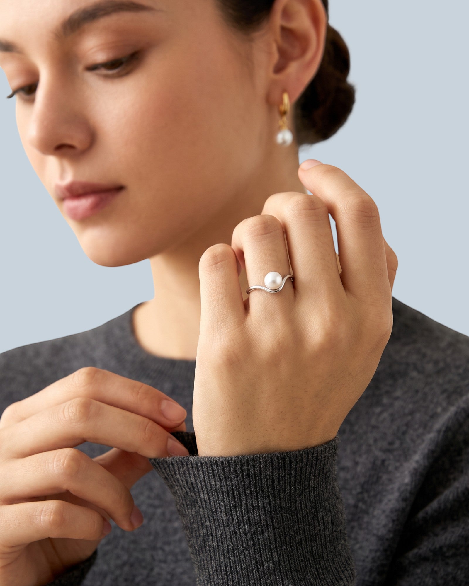 Pearlystones minimalist V-shaped silver ring with a natural freshwater pearl worn on a woman's finger