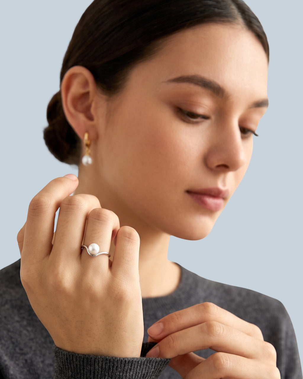 Pearlystones minimalist V-shaped ring with a natural freshwater pearl worn on a model's finger in silver finish