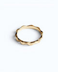 Pearlystones gold wavy band ring with geometric facets, a modern and elegant statement piece.