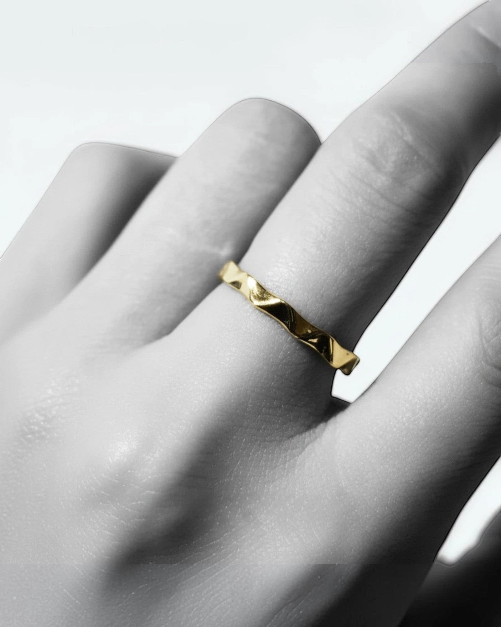 Pearlystones gold wavy band ring with geometric facets, a modern statement piece.