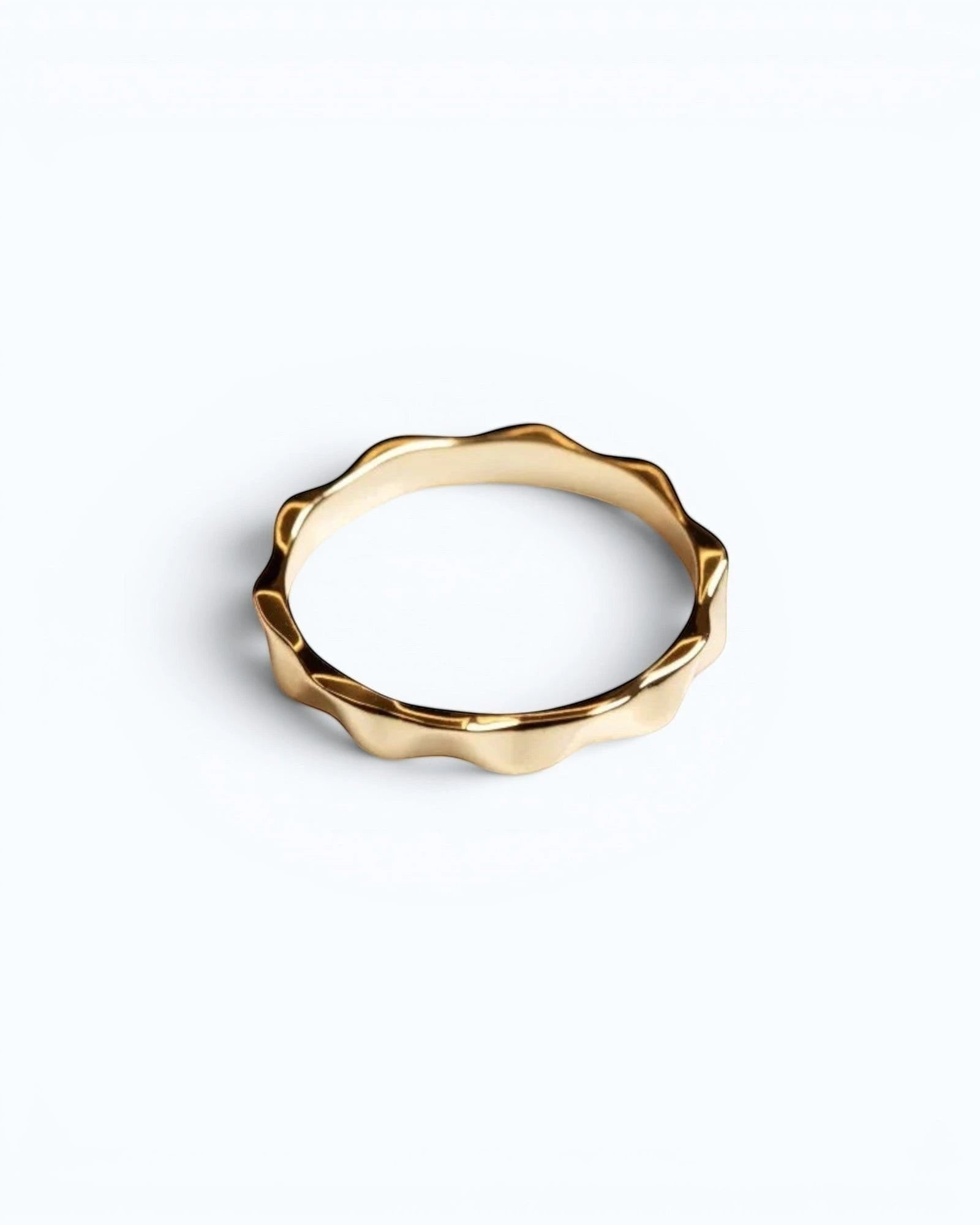 Pearlystones gold wavy band ring with geometric facets, a modern and elegant statement piece.