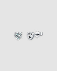 Heart-shaped diamond stud earrings on a light gray background