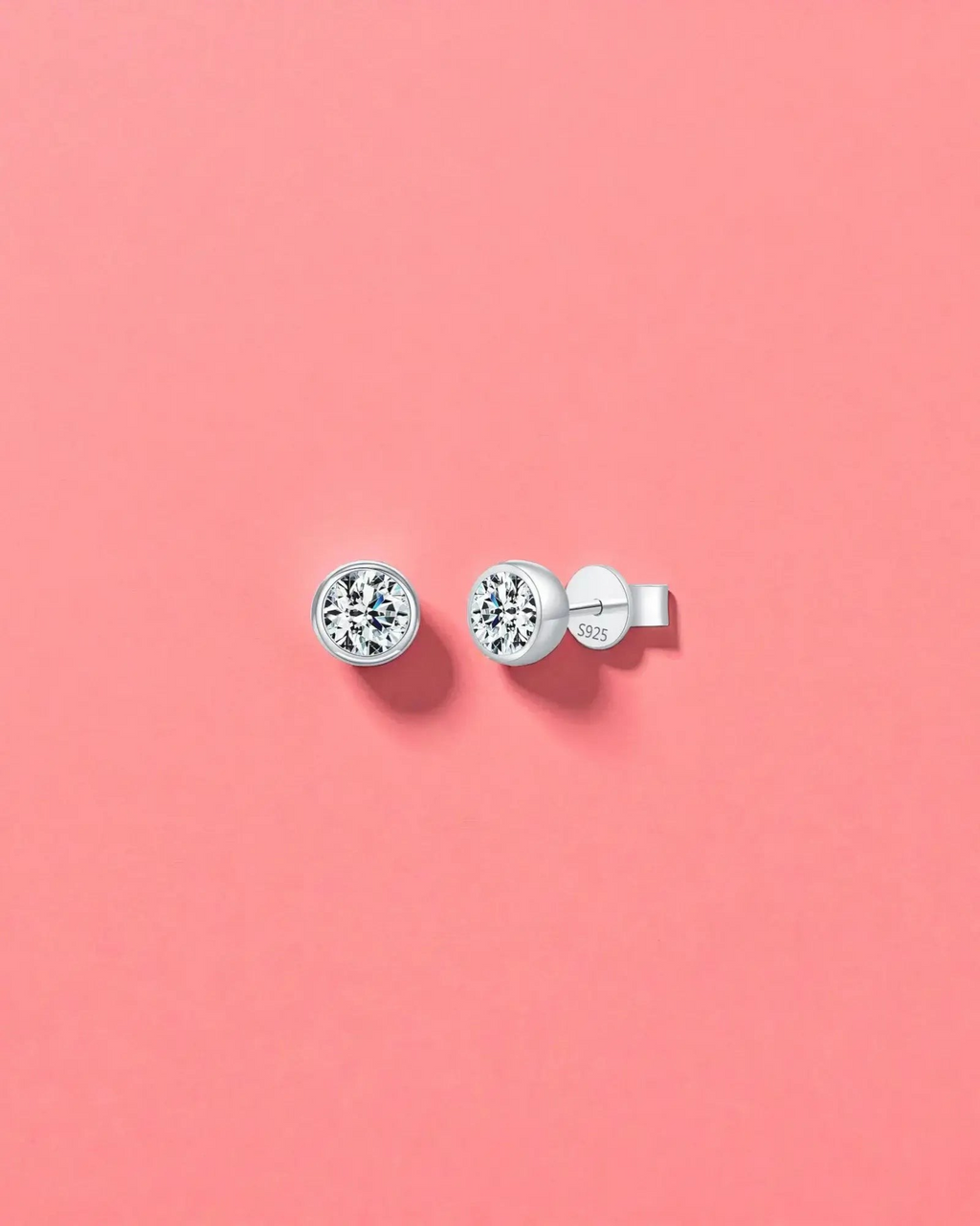 1Ct Round Bubble moissanite studs on a pink background, made with sterling silver and rhodium finishing, perfect for everyday wear.