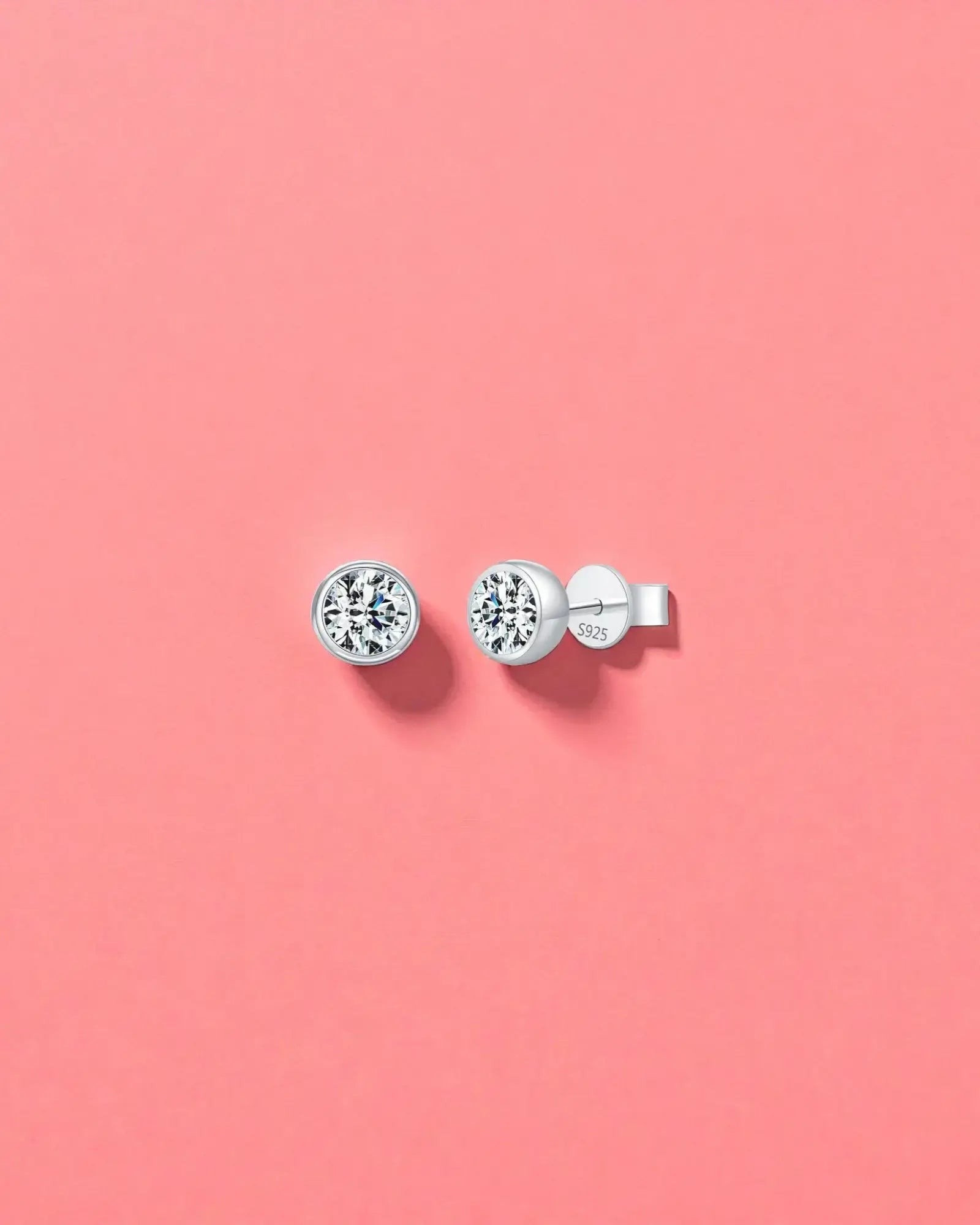 1Ct Round Bubble moissanite studs on a pink background, made with sterling silver and rhodium finishing, perfect for everyday wear.