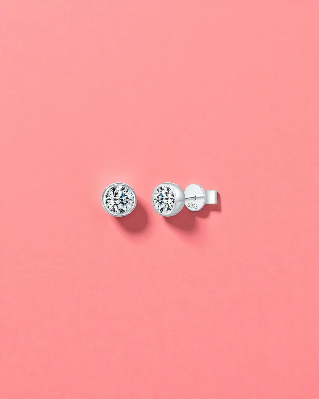 1Ct Round Bubble moissanite studs on a pink background, made with sterling silver and rhodium finishing, perfect for everyday wear.