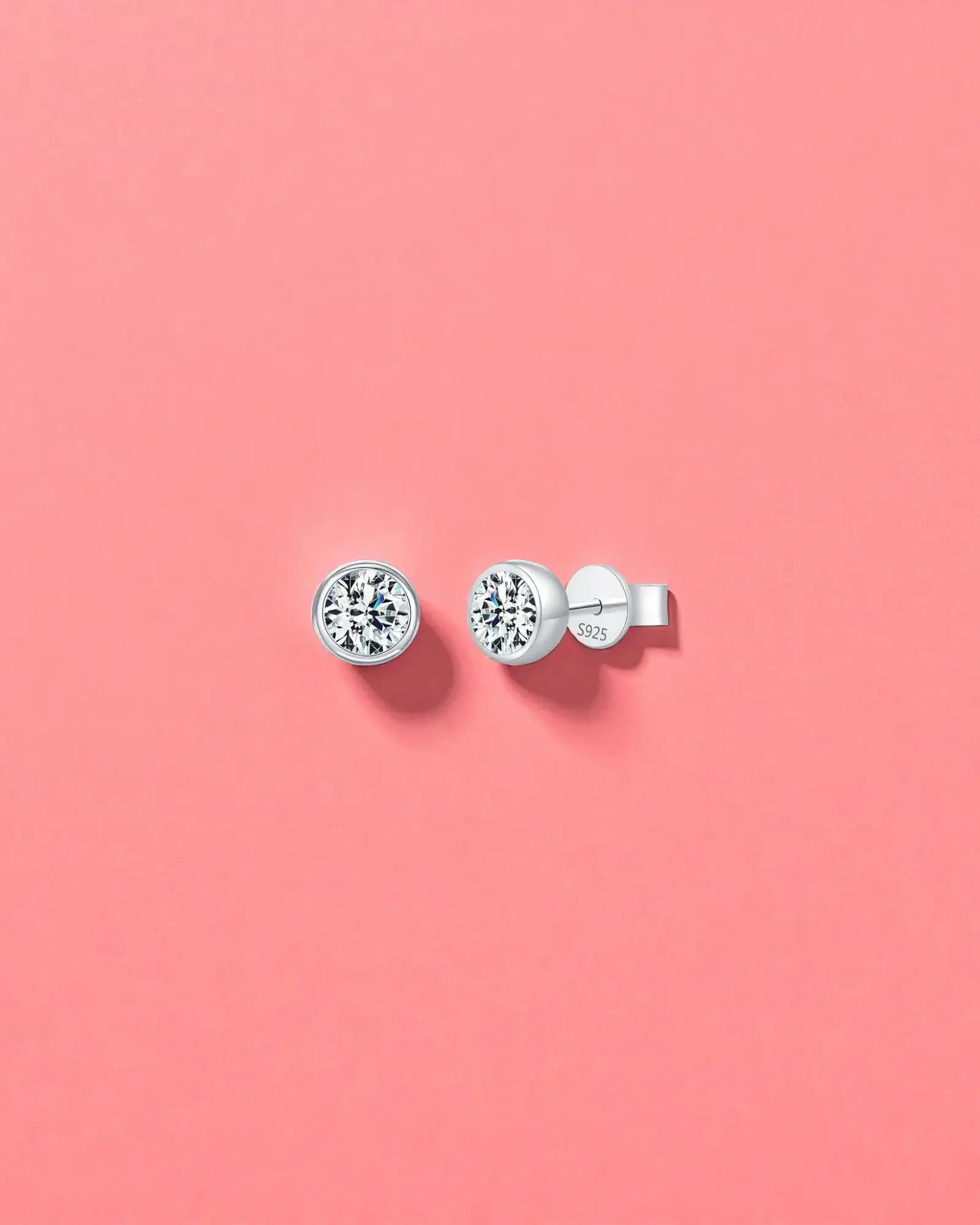 1Ct Round Bubble moissanite studs on a pink background, made with sterling silver and rhodium finishing, perfect for everyday wear.