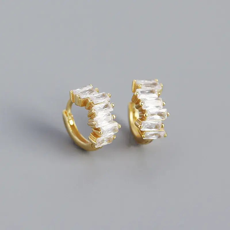 Gold-plated sleeper hoops featuring sparkling baguette cut stones, perfect for adding elegance to any outfit.