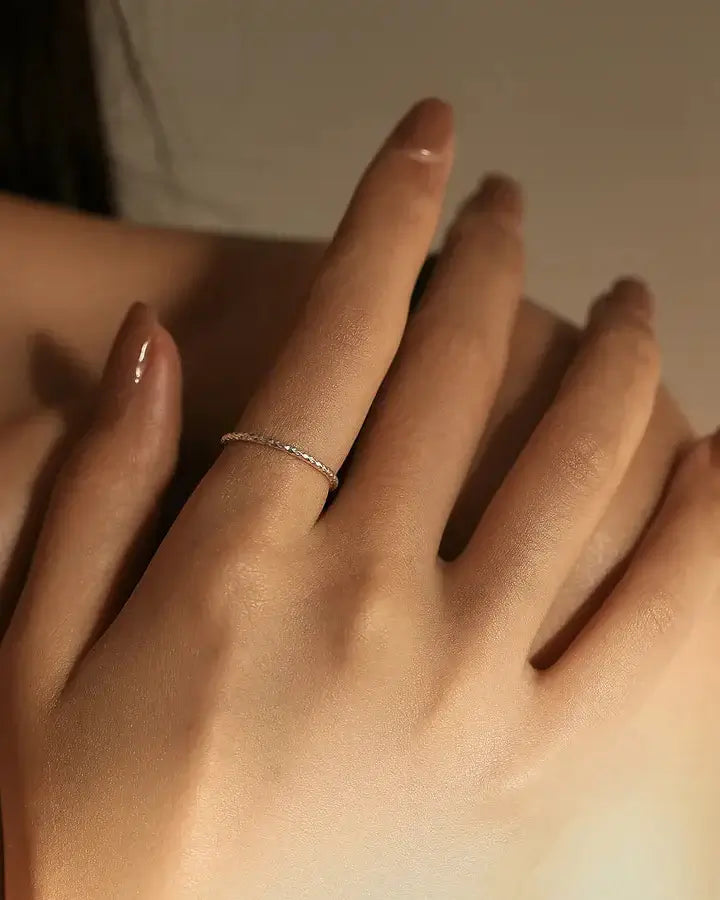 Elegant silver wave textured ring worn on a hand, showcasing a sleek and comfortable design, perfect for daily wear.