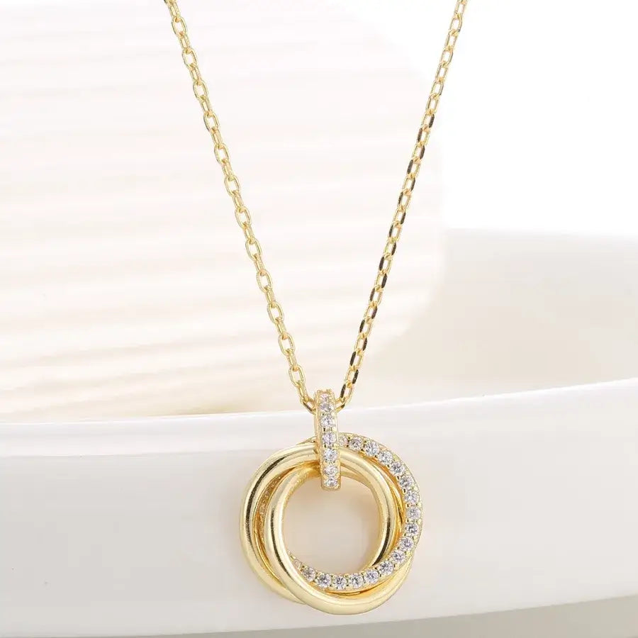 Three-loop pendant necklace in gold plating with sparkling accents, showcasing elegant design and versatility.