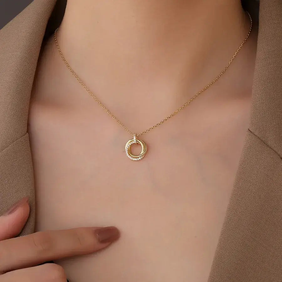 Elegant three-loop pendant necklace in gold plating, worn with a stylish outfit, showcasing its versatility and modern design.