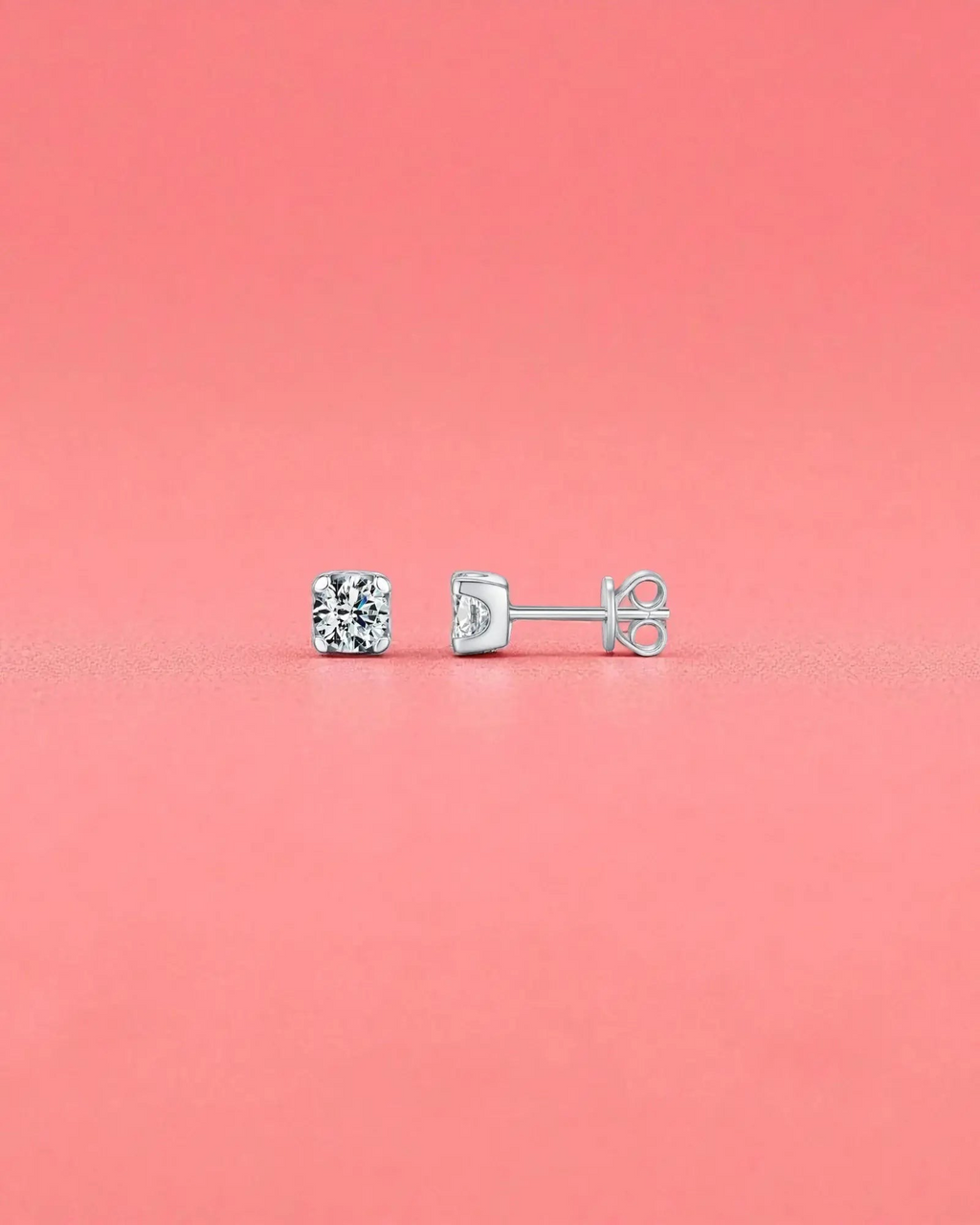 5mm Round brilliant cut moissanite studs with sterling silver and rhodium finish on a pink background.