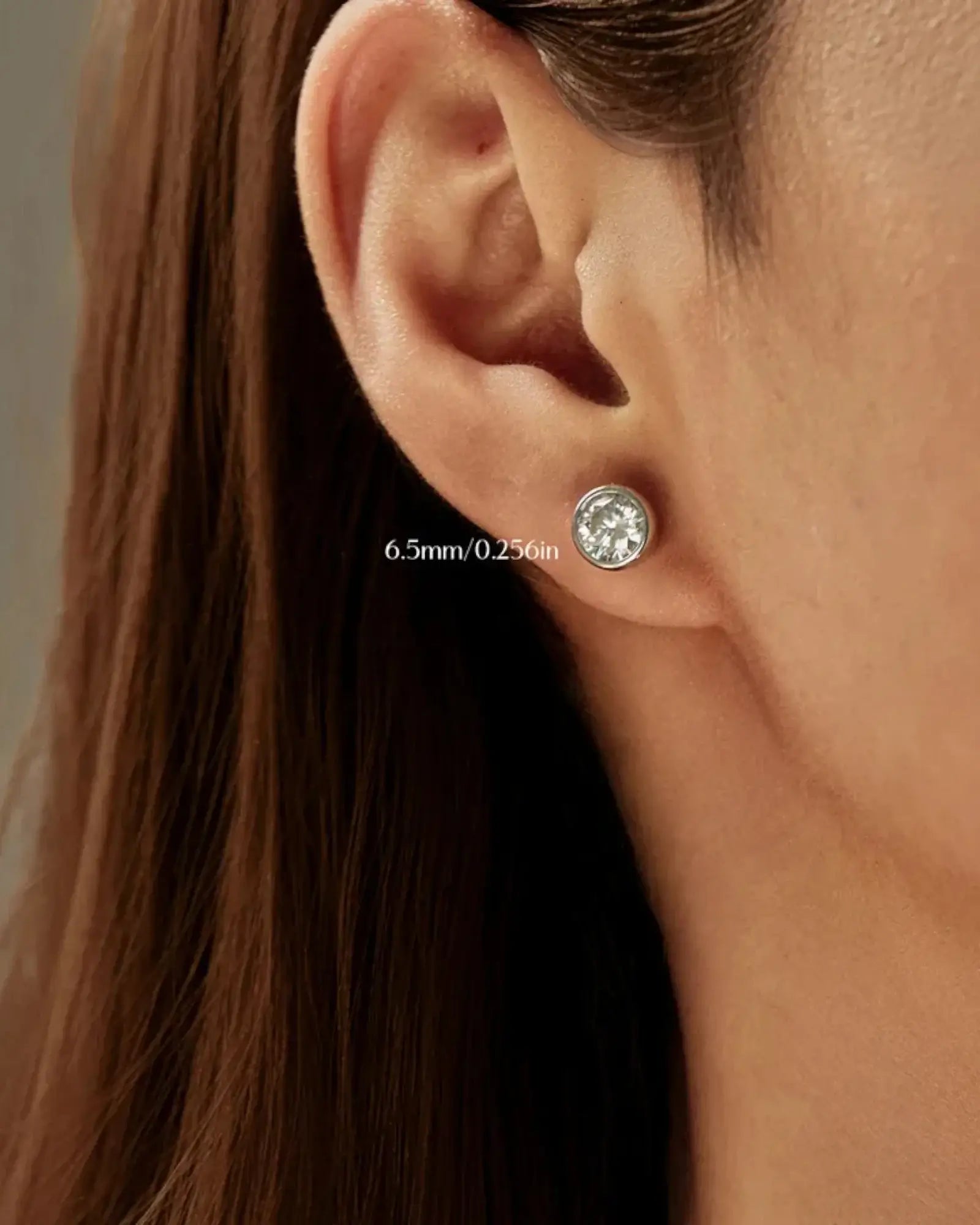 2Ct Round Bubble Moissanite studs showcased in a close-up of an ear, featuring a 6.5mm sparkling stone.