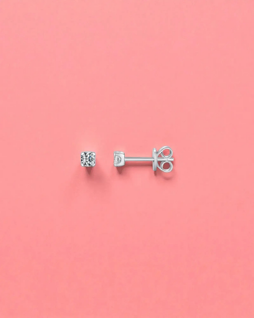 3mm Round brilliant cut moissanite studs on a pink background, showcasing their sterling silver and rhodium finish.
