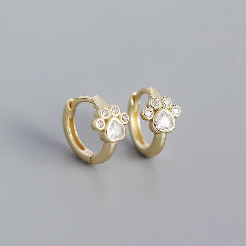 Gold cat paw print sleeper earrings with sparkling accents, elegant and comfortable design.