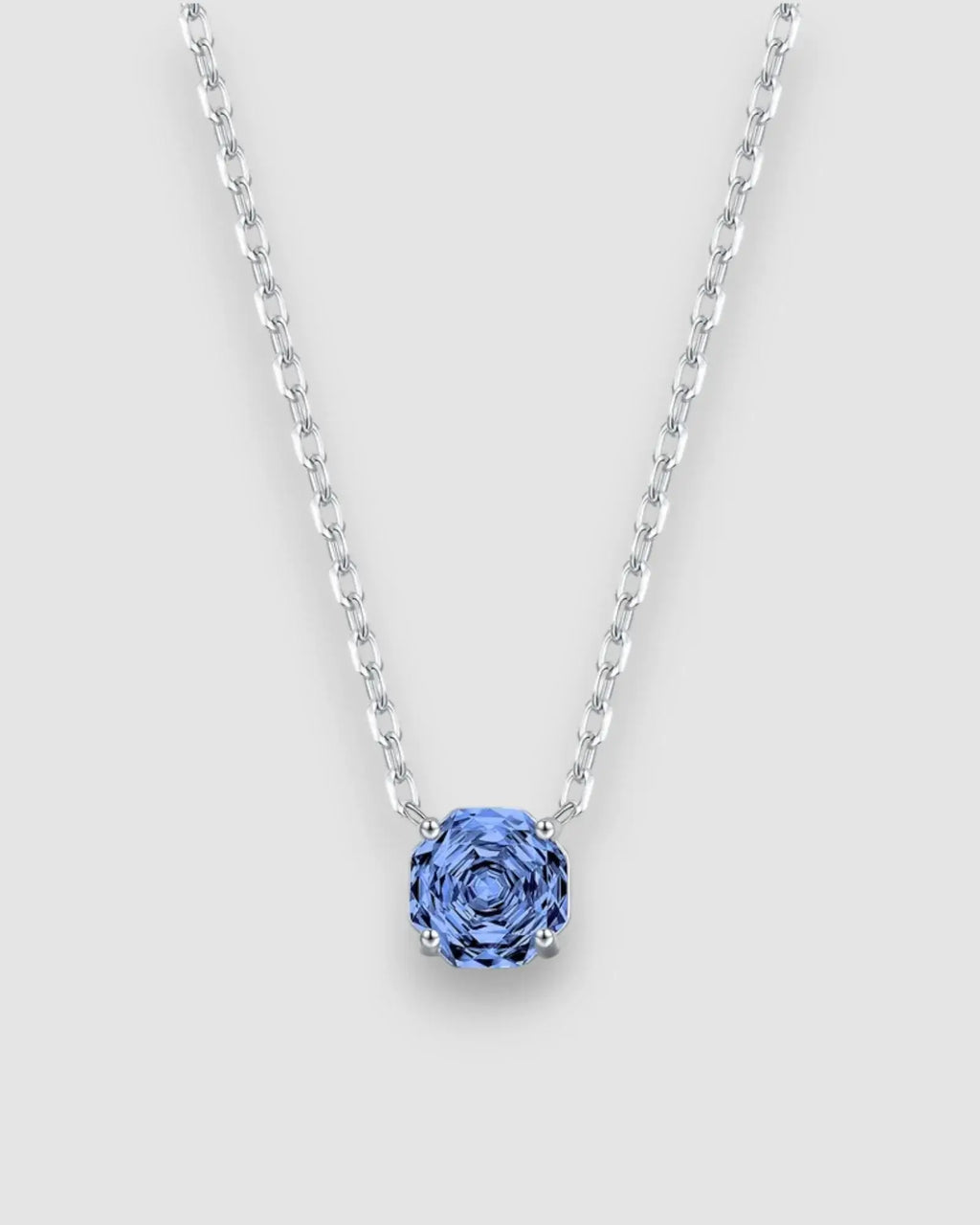 Octagonal Rose Cut Tanzanite Blue Zircon Pendant Necklace in Silver showcasing a blue stone on a silver chain.