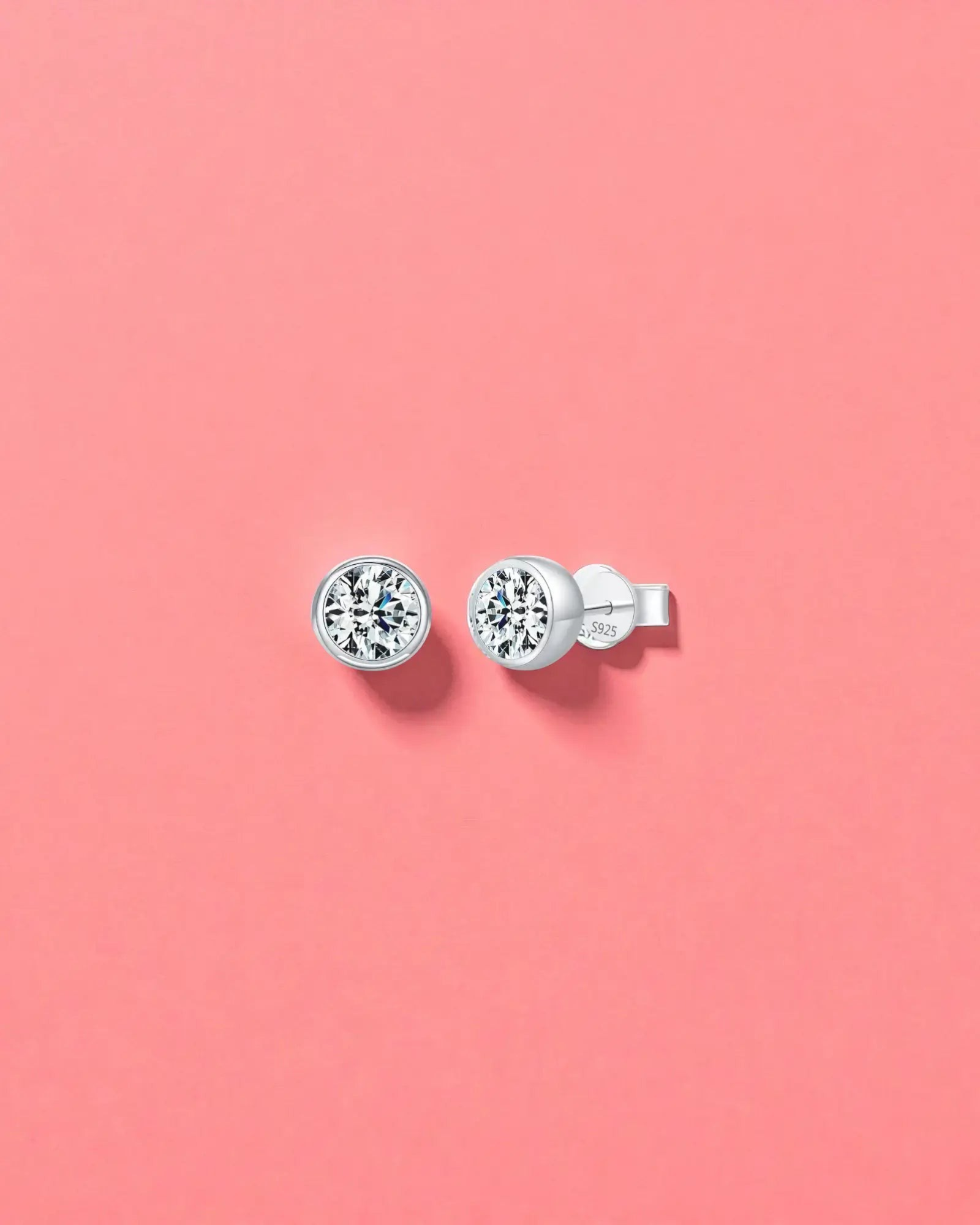 2Ct Round Bubble Moissanite studs displayed on a pink background, featuring sterling silver and rhodium finishes.