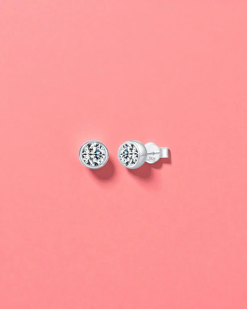 2Ct Round Bubble Moissanite studs displayed on a pink background, featuring sterling silver and rhodium finishes.