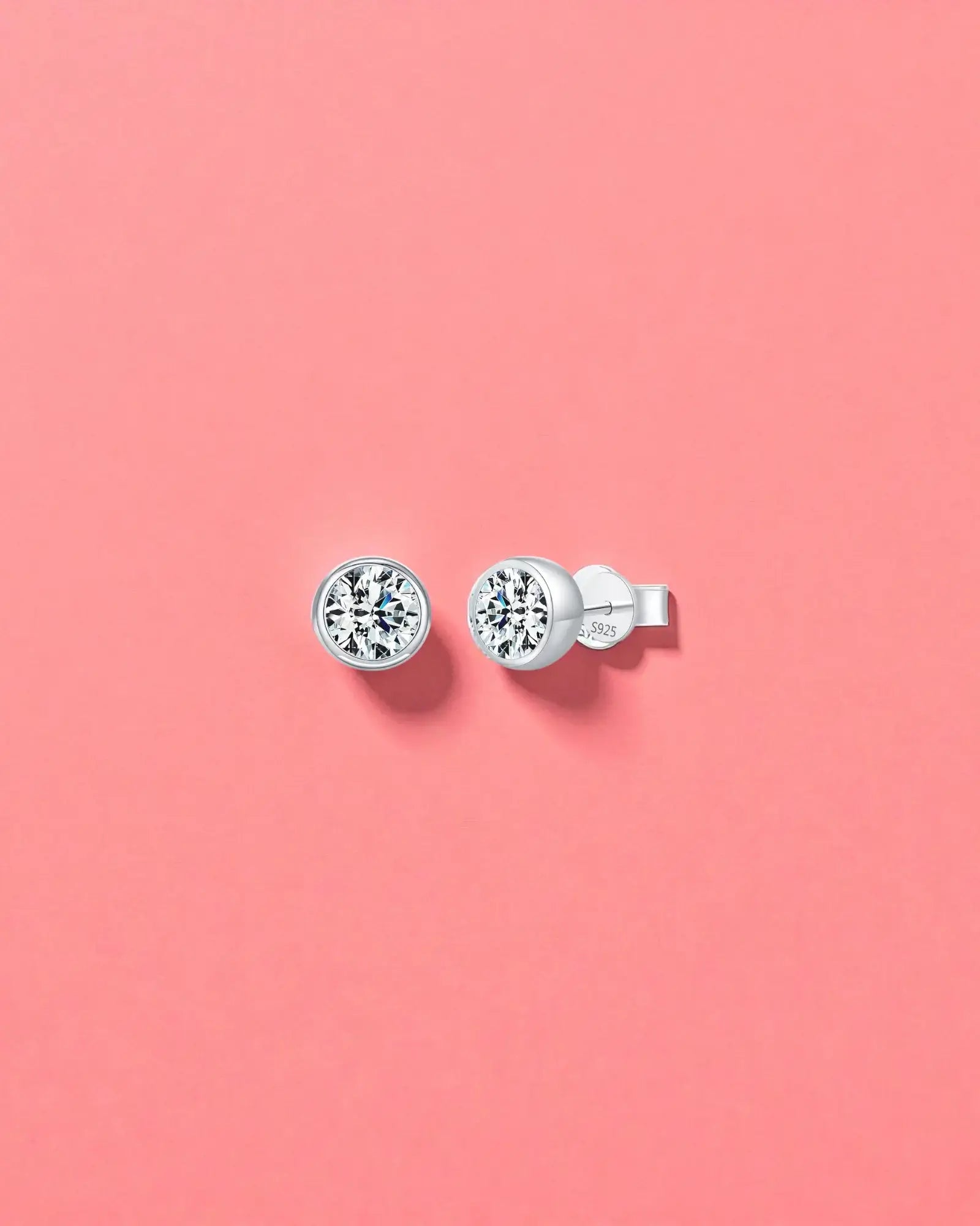 2Ct Round Bubble Moissanite studs displayed on a pink background, featuring sterling silver and rhodium finishes.
