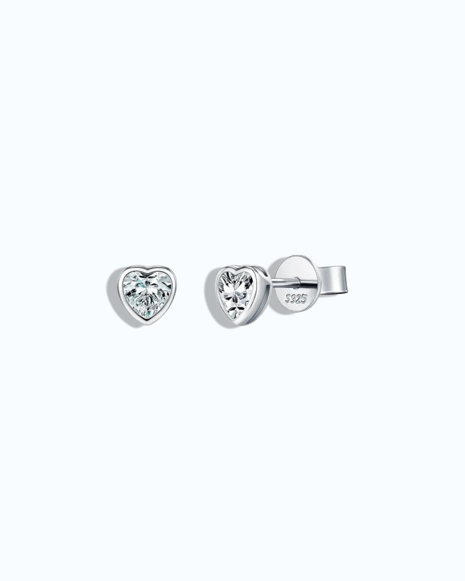 Heart-shaped silver earrings with clear gemstones on a light gray background