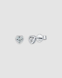 Heart-shaped silver earrings with clear gemstones on a light gray background