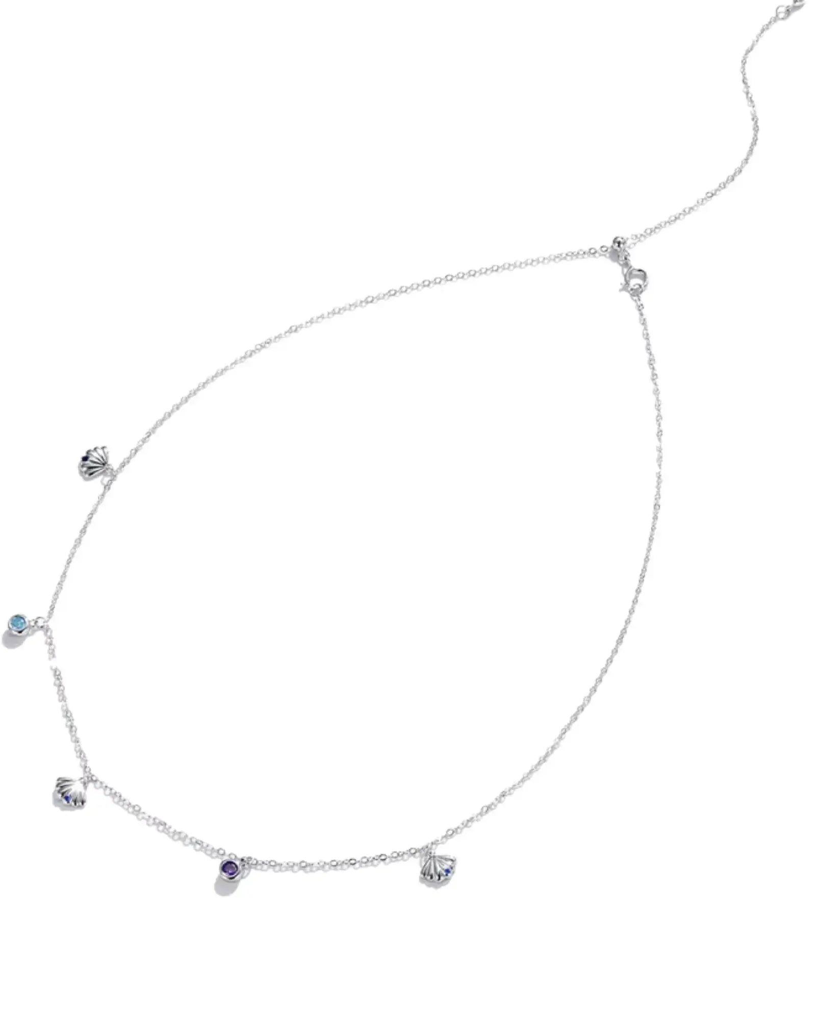 Scallop charm necklace in silver with blue zircon, featuring delicate scallop details and adjustable chain length.