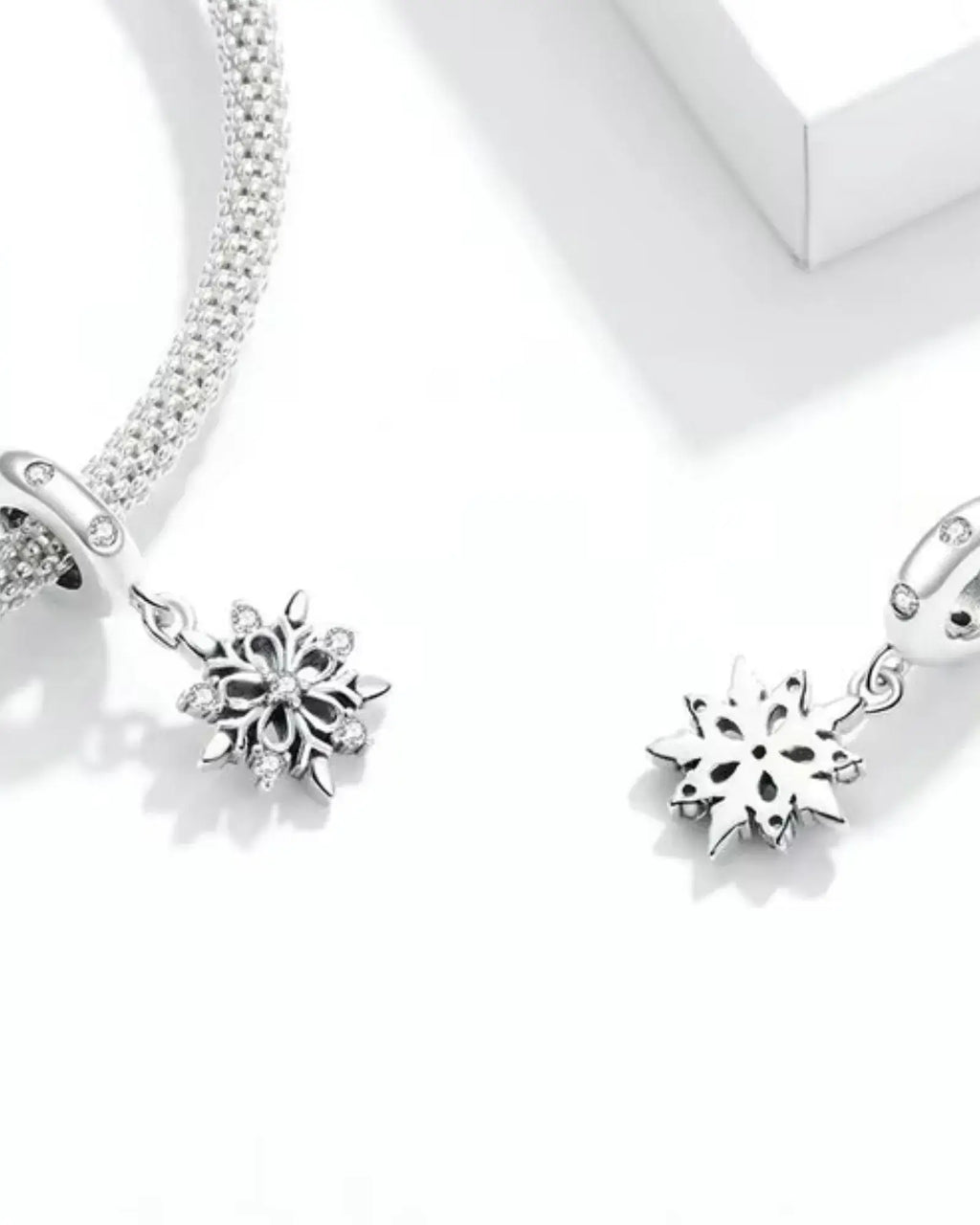 Elegant 925 sterling silver snowflake charms on a bracelet, featuring intricate pave settings and romantic design.