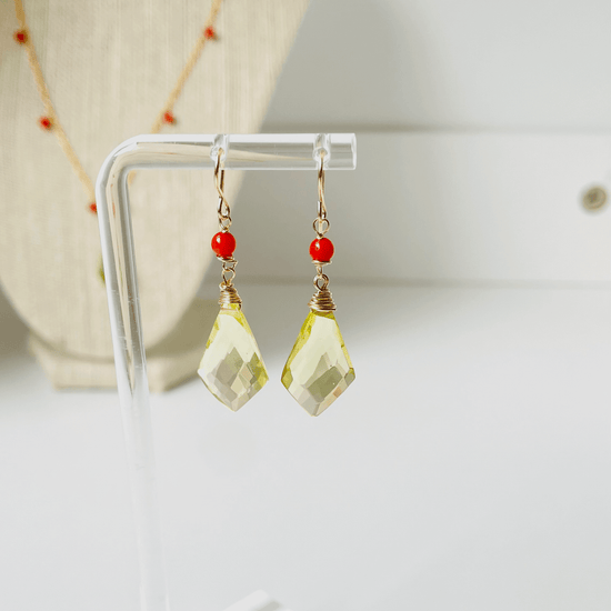 a pair of yellow and red earrings on a stand