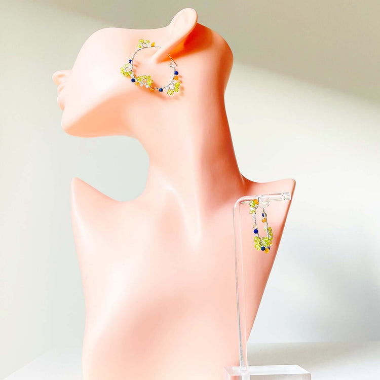 a pink mannequin with a pair of earrings on it