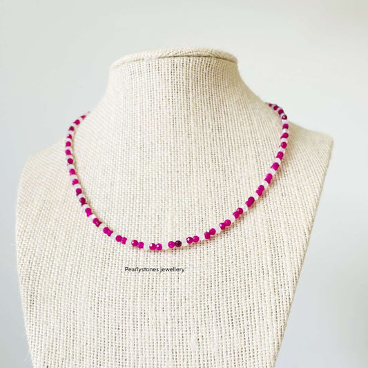 a necklace with pink beads on a mannequin